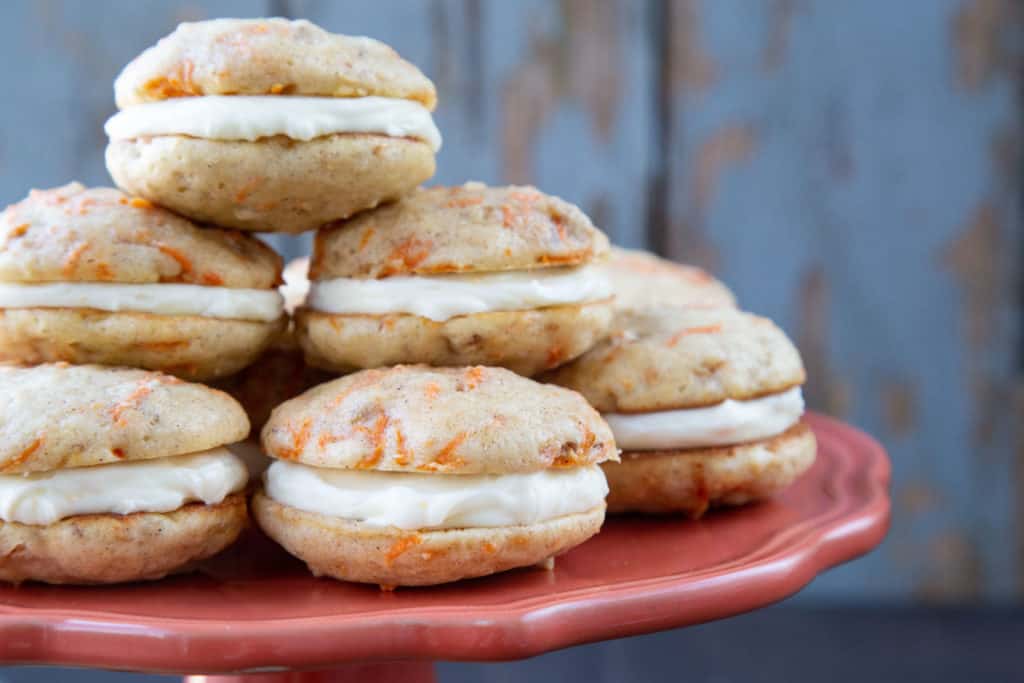 carrot cake whoopie pies on a pink cake stand