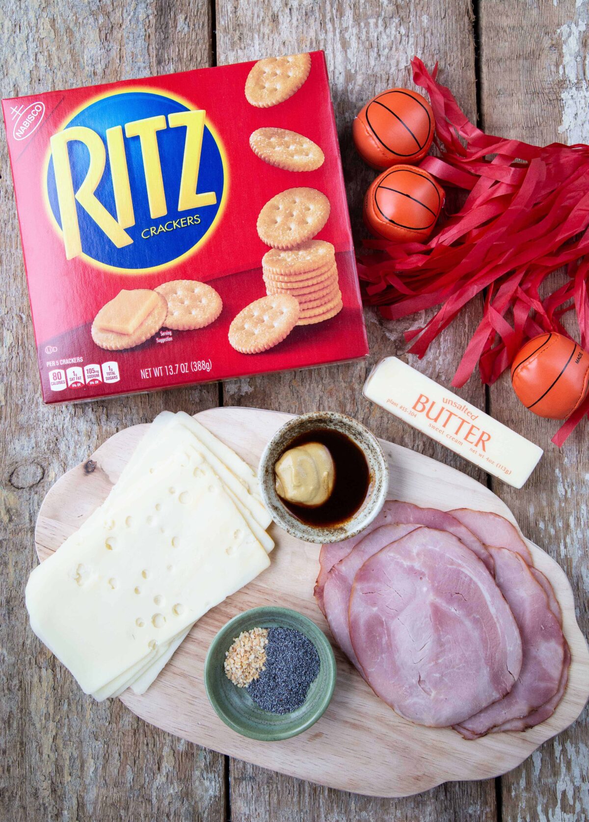 Ingredients for Ritz Crackers Party Sandwiches on a wooden table.