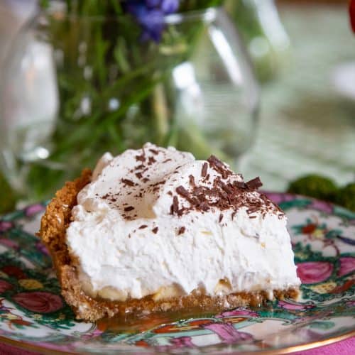 slice of banoffee pie on a pink and green china plate.