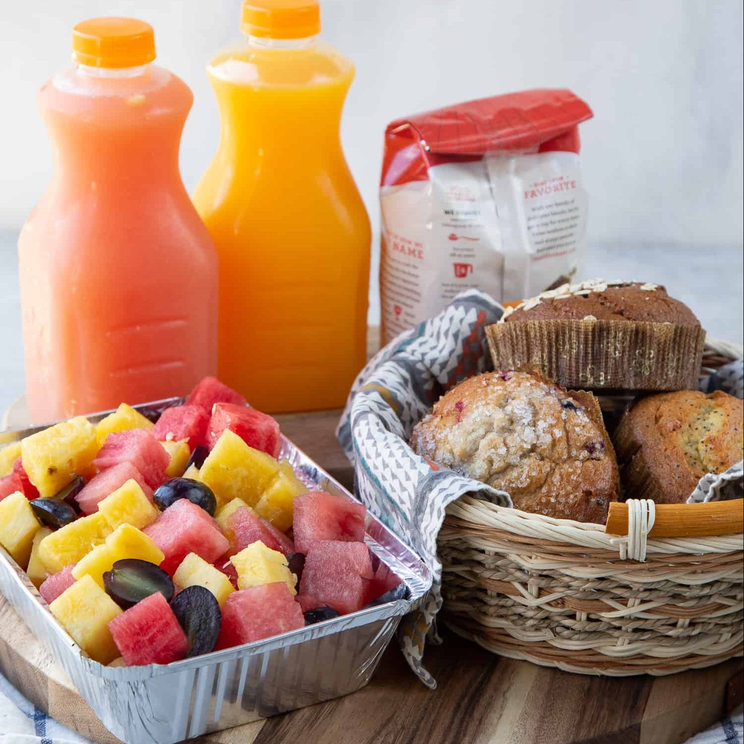 Breakfast basket with muffins, fruit, and juice