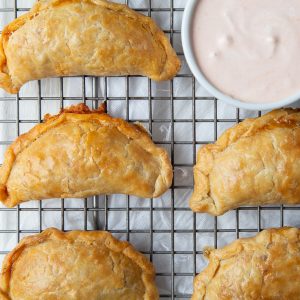 chicken enchilada empanadas on a wire rack.