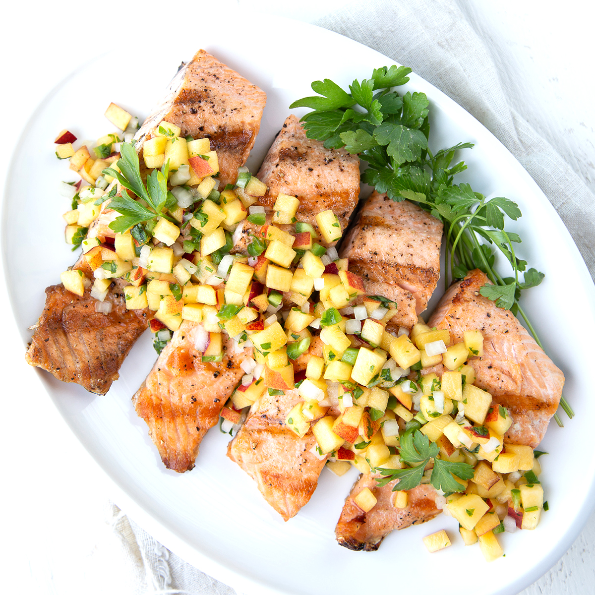 salmon with nectarine salsa on a white platter