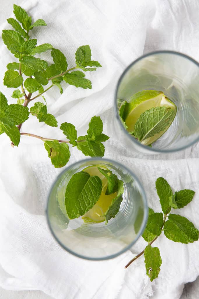 Lime segments and mint leaves in tall glasses