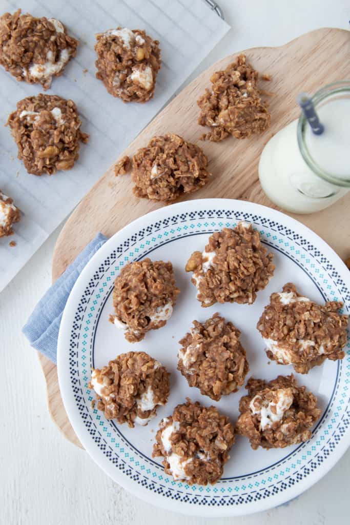 no bake cookies on a white plate with a jar of milk nearby