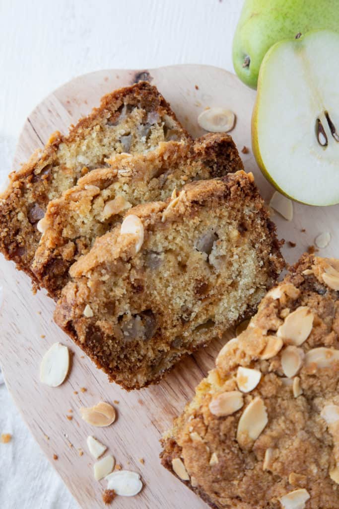 slices of pear bread sitting on a wooden cutting board