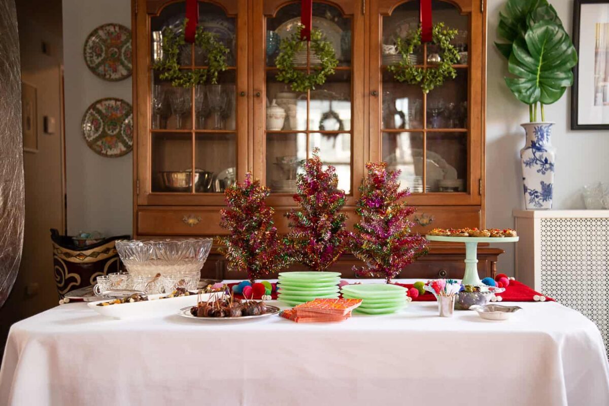 long table with a white tablecloth and appetizers on top.