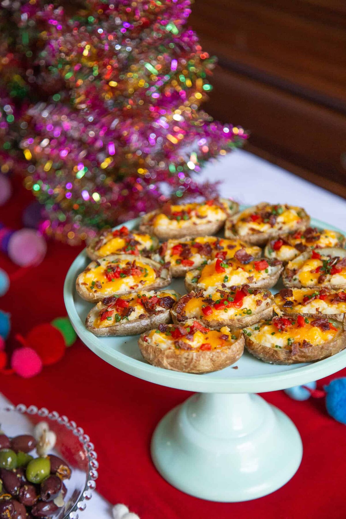 jade green cake stand with stuffed potato skins on top.