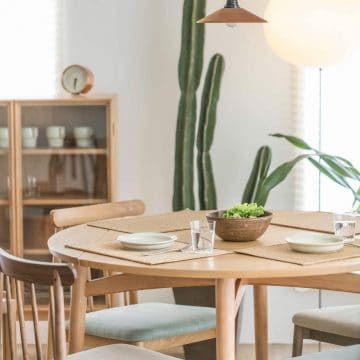 dining table set for dinner with a large cactus in the background.
