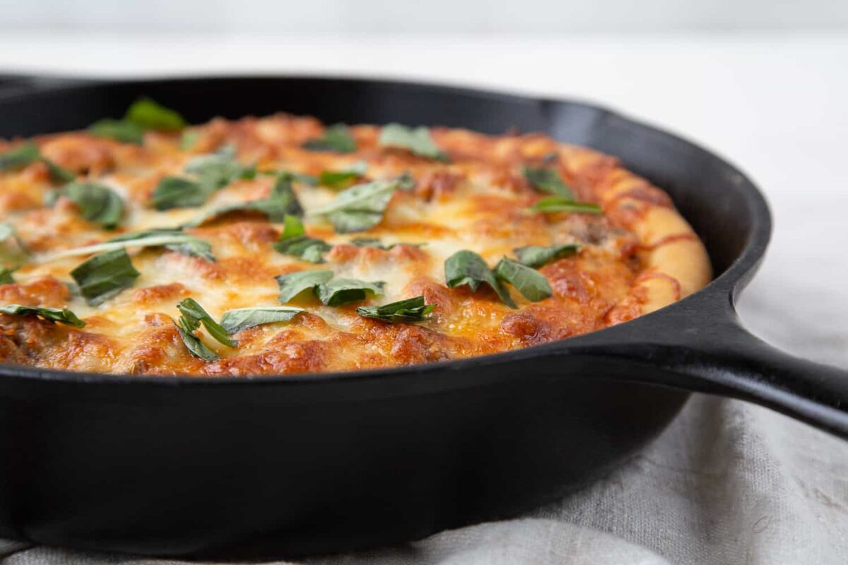 Side view of pizza made in a cast iron skillet.