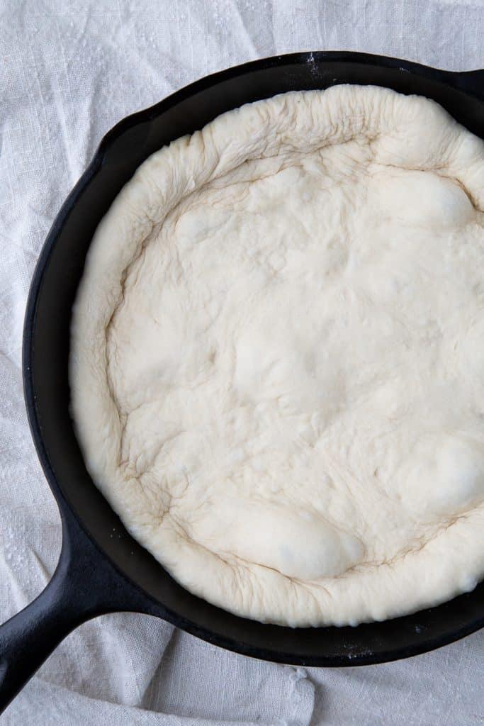pizza dough in a cast iron pan.