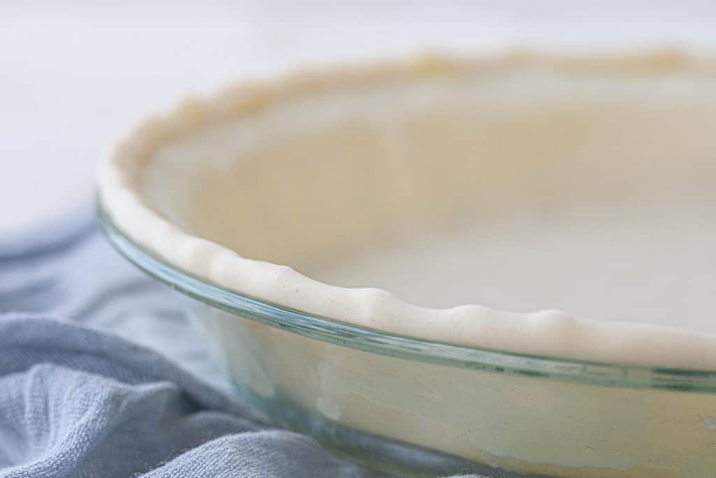 Raw pie dough in a glass dish