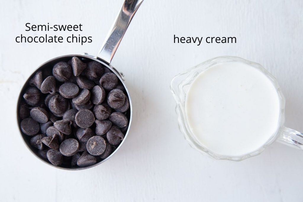 chocolate chips and heavy cream in a glass cup on a white background