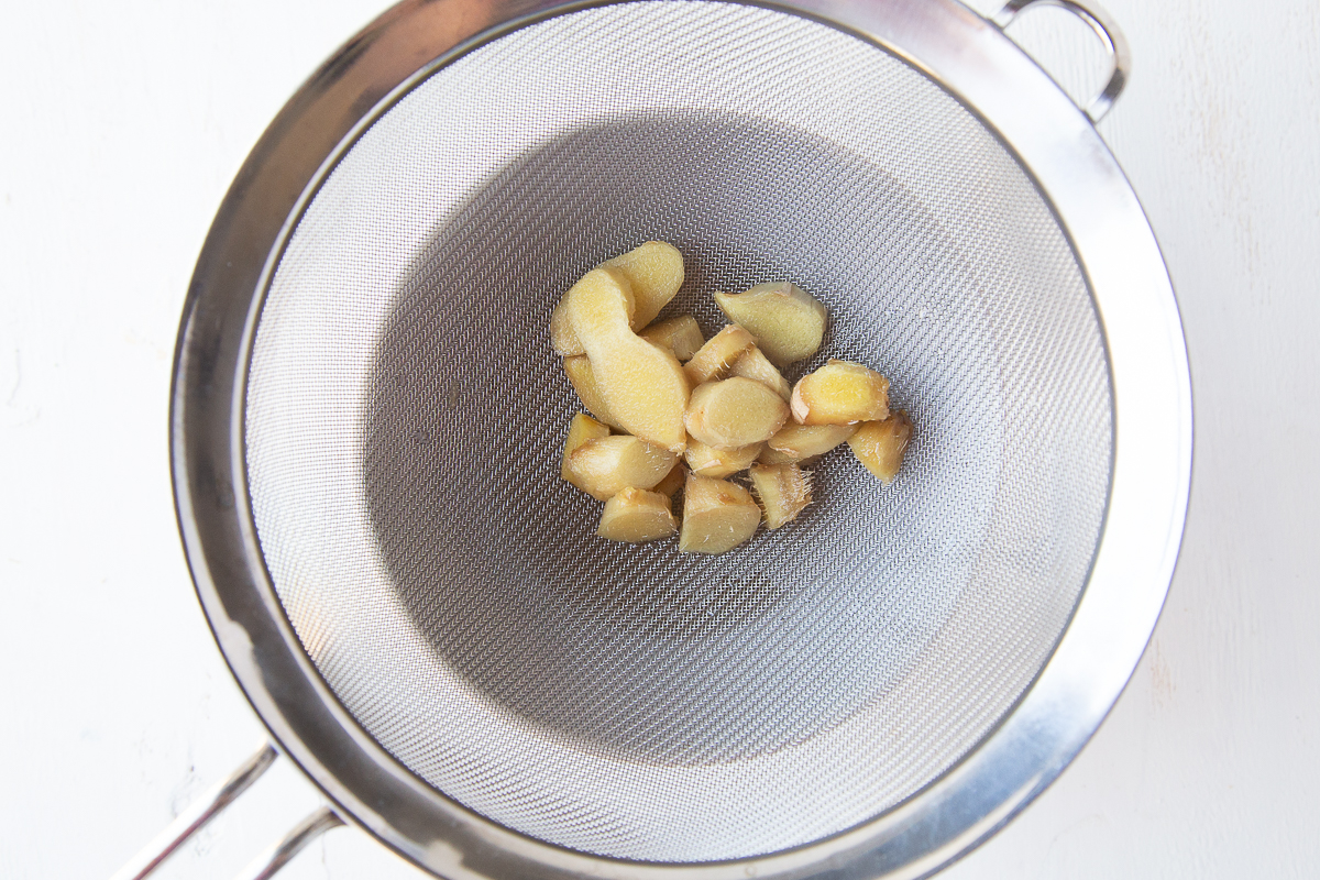 coins of ginger sitting in a mesh colander