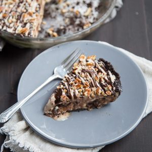 Slice of ice cream pie on a gray plate with a fork nearby