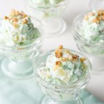 glass parfait glasses filled with pistachio salad, on a green napkin