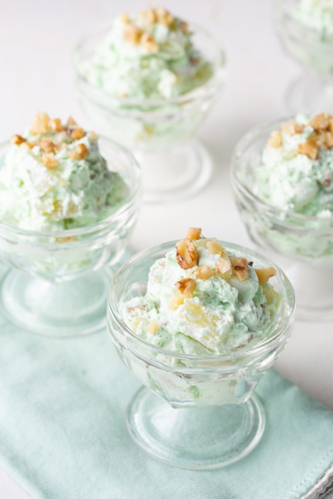 glass parfait glasses filled with pistachio salad, on a green napkin