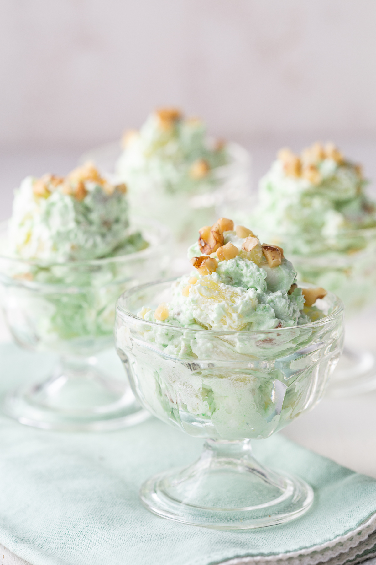 pistachio salad in mini parfait dishes, topped with chopped walnuts.