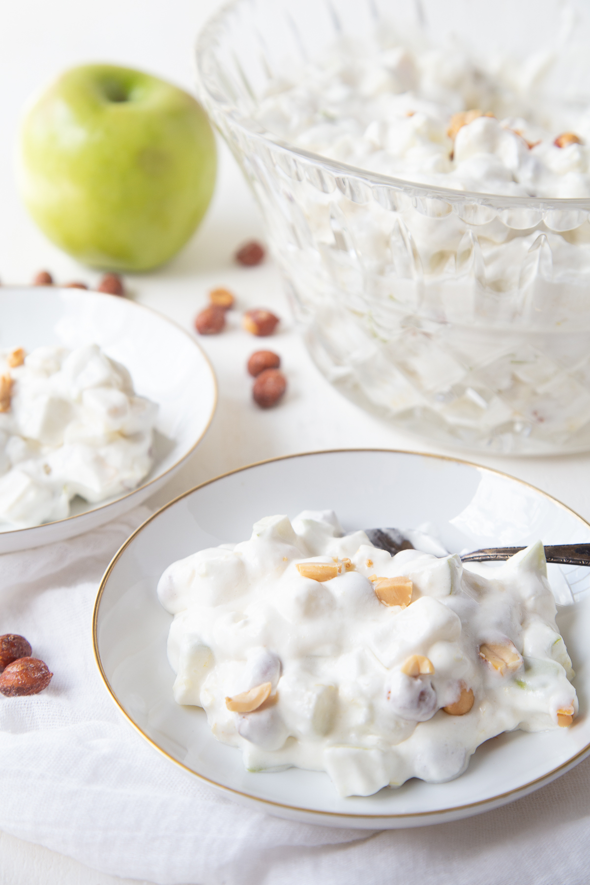 Taffy apple salad in a small white dish, with a larger glass serving dish in the background