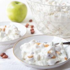 Taffy apple salad in a small white dish with a large glass serving dish in the background