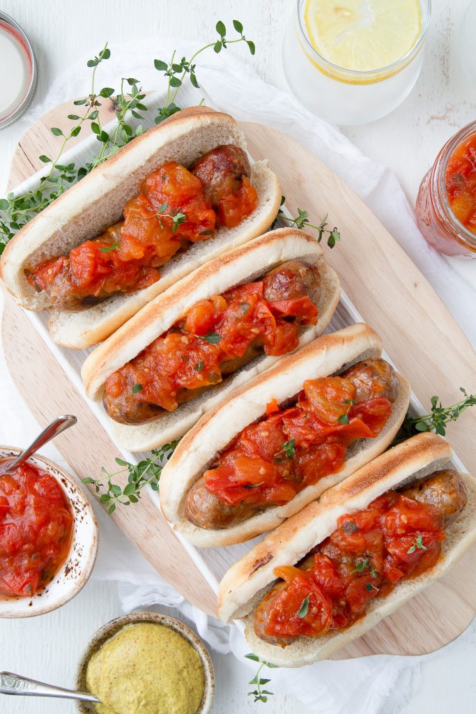 tomato jam on bratwursts on a wooden board