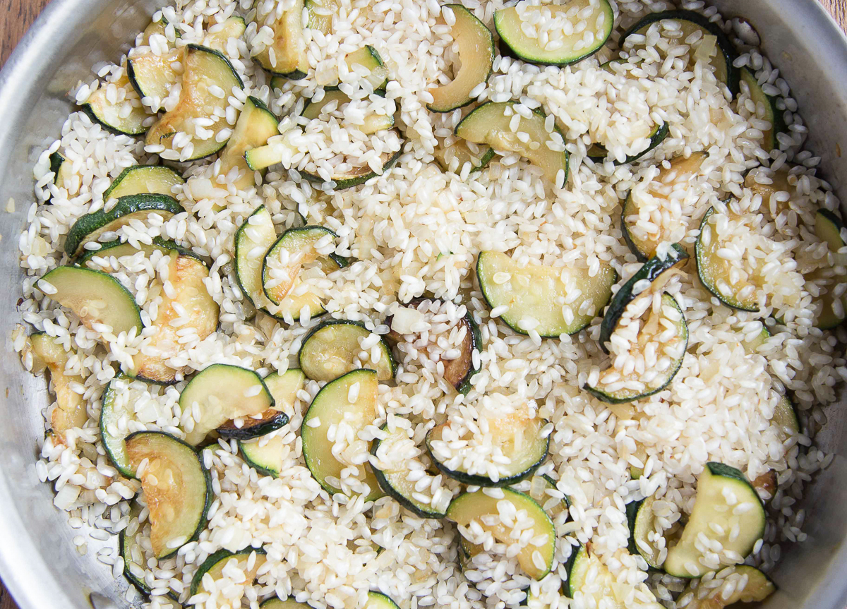 arborio rice and zucchini in a metal pan