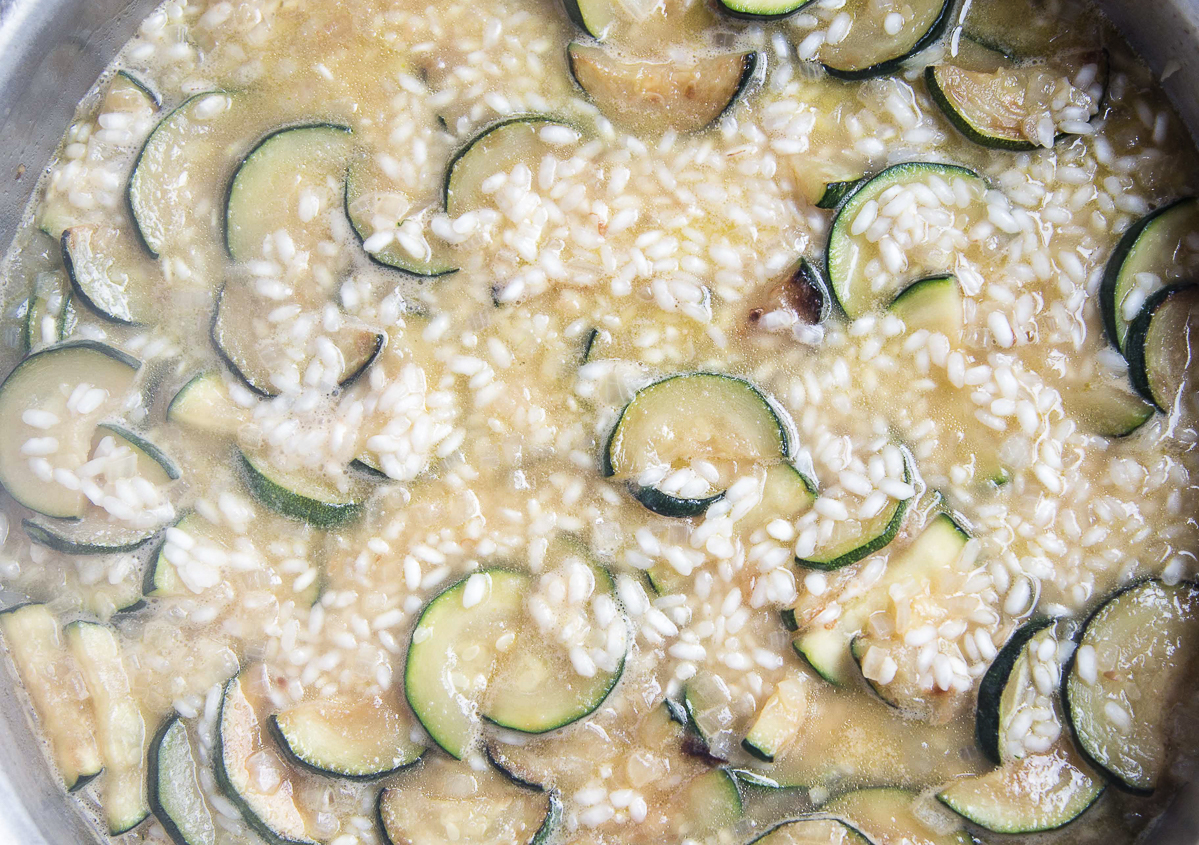 process of making risotto in a metal pan 