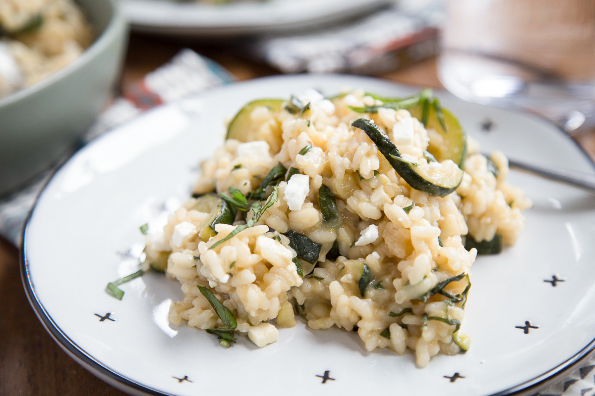 zucchini risotto with herbs on a white plate