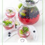 glass pitcher of blueberry mojitos surrounded by a lime wedge and fresh blueberries