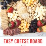 cheese, crackers, and fruit on a wooden board