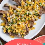 grilled pork chops with peach salsa on a white platter