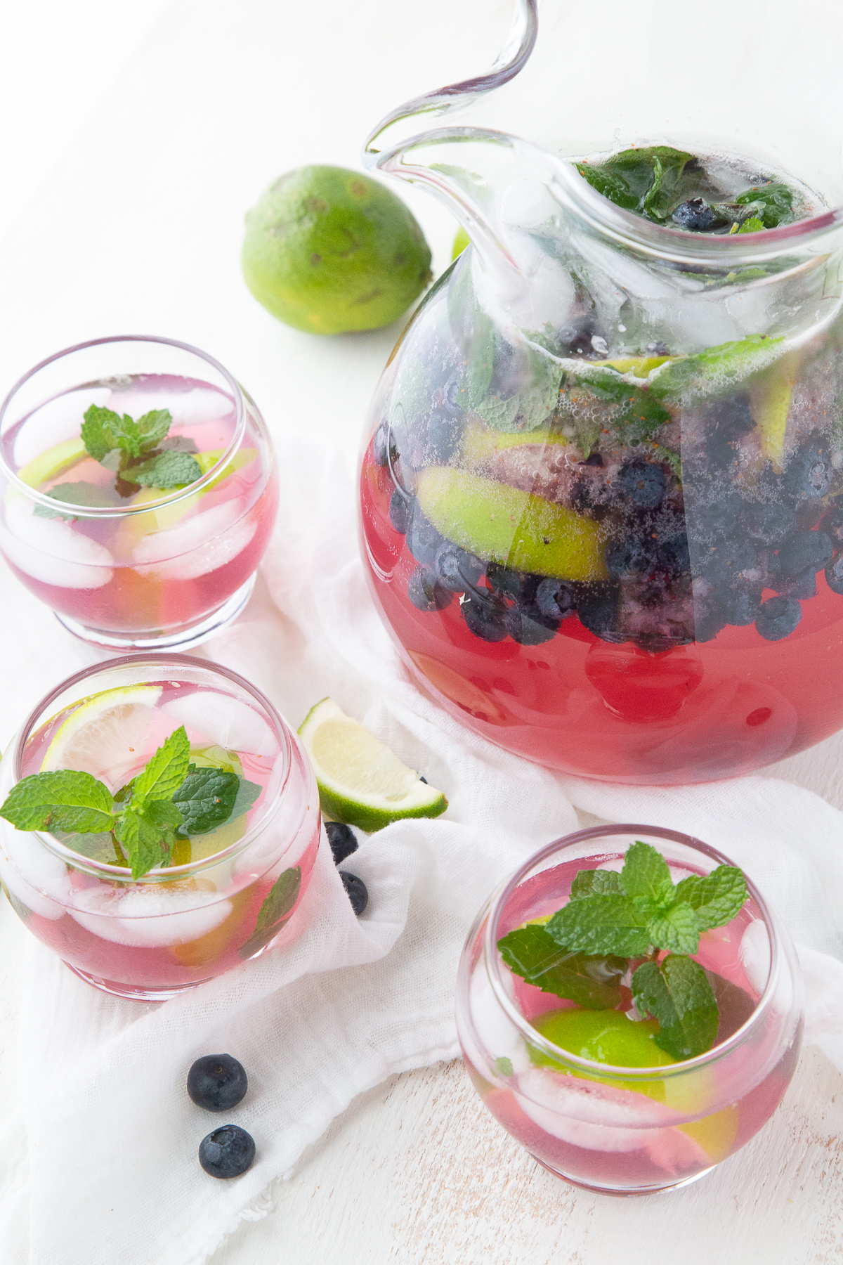 pitcher and glasses filled with blueberry mojitos