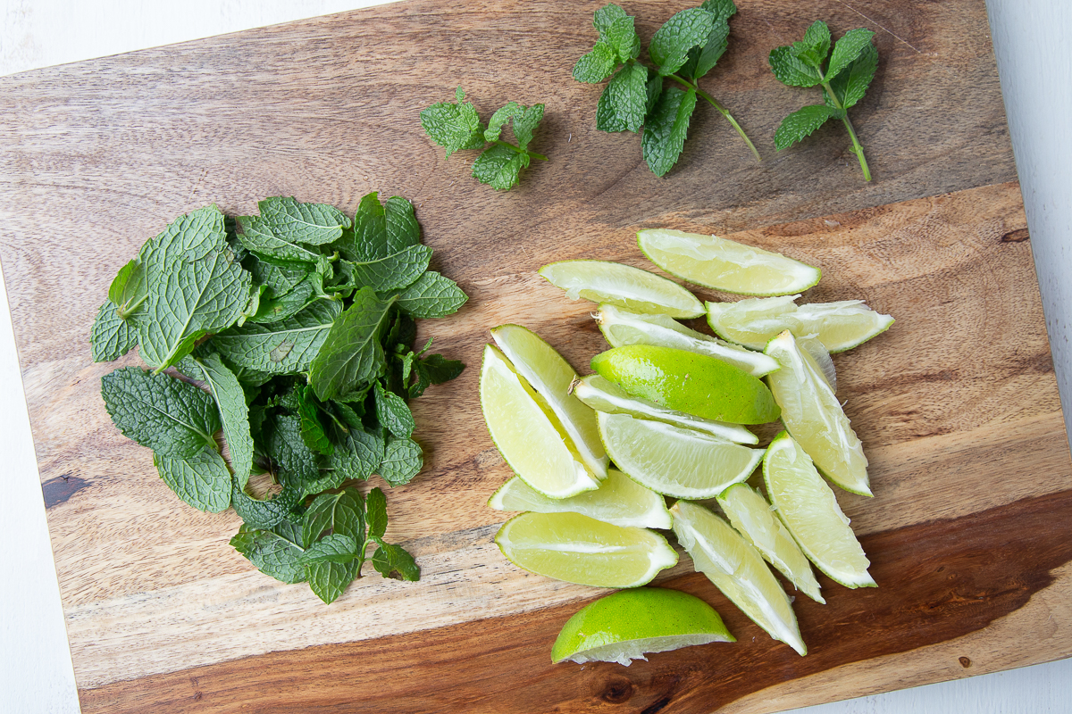 lime wedges and mint leaves on a wooden board