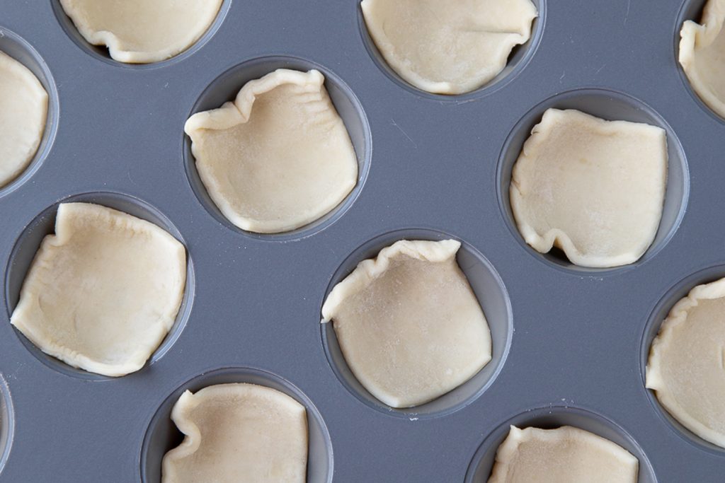 Puff pastry squares in muffin tin