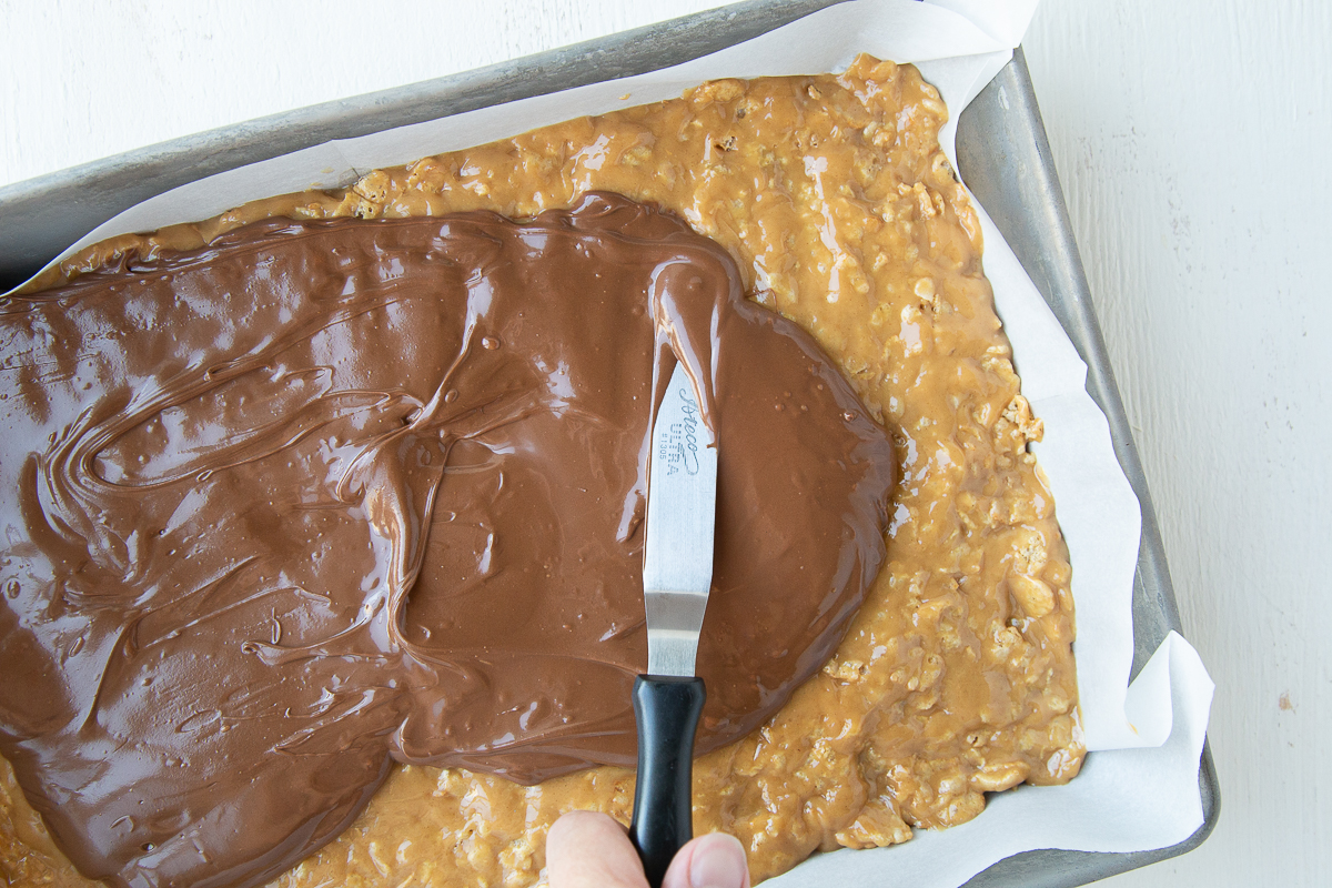 spatula spreading chocolate on top of bars