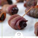 bacon wrapped date with a toothpick on white parchment paper