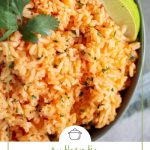 mexican rice garnished with limes in a green bowl