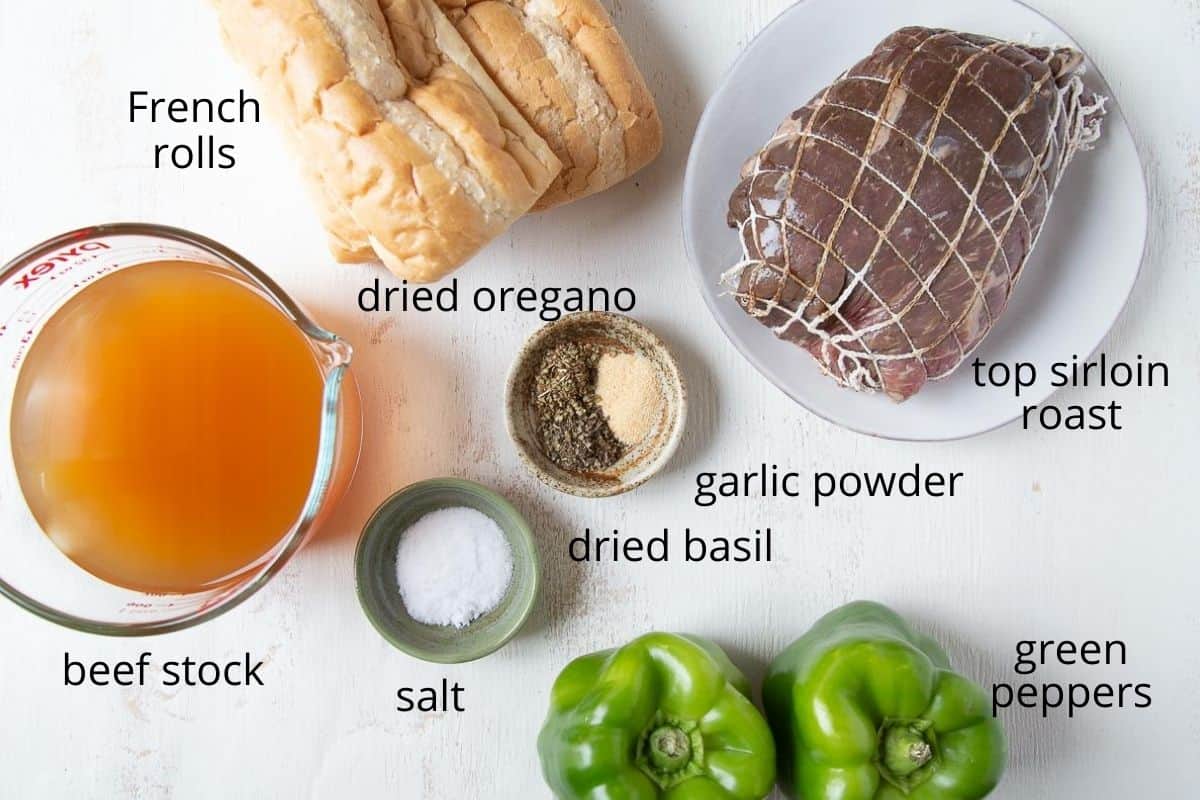 ingredients for italian beef sandwiches on a white table.