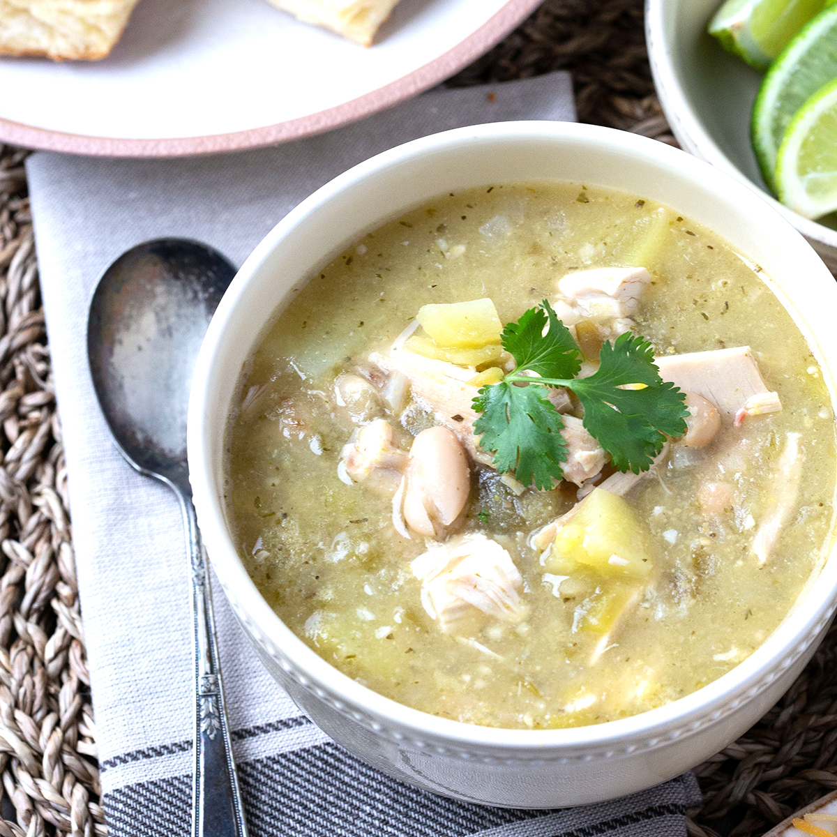 bowl of white chicken chili with an antique spoon next to it