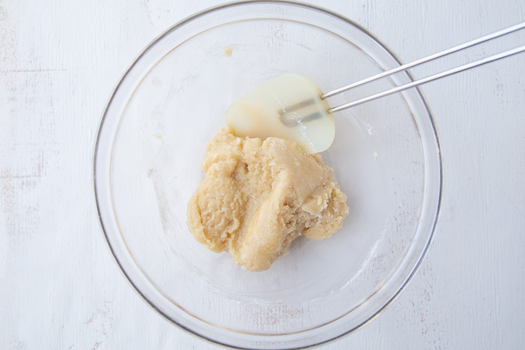 coconut bar dough in a glass bowl with a spatula