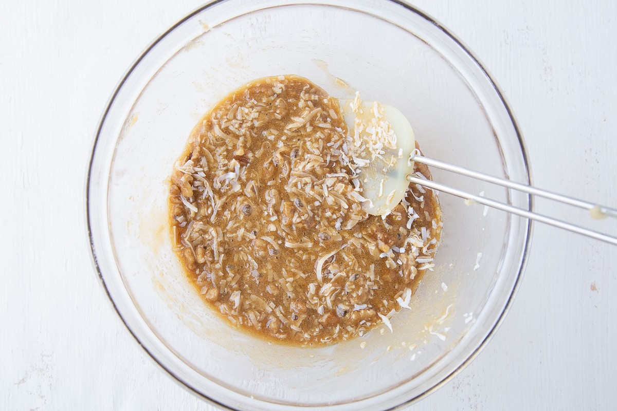 coconut filling for coconut bars in a glass bowl with a spatula