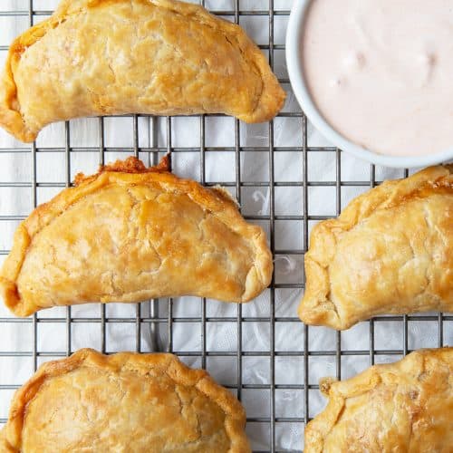 golden brown empanadas on a wire rack