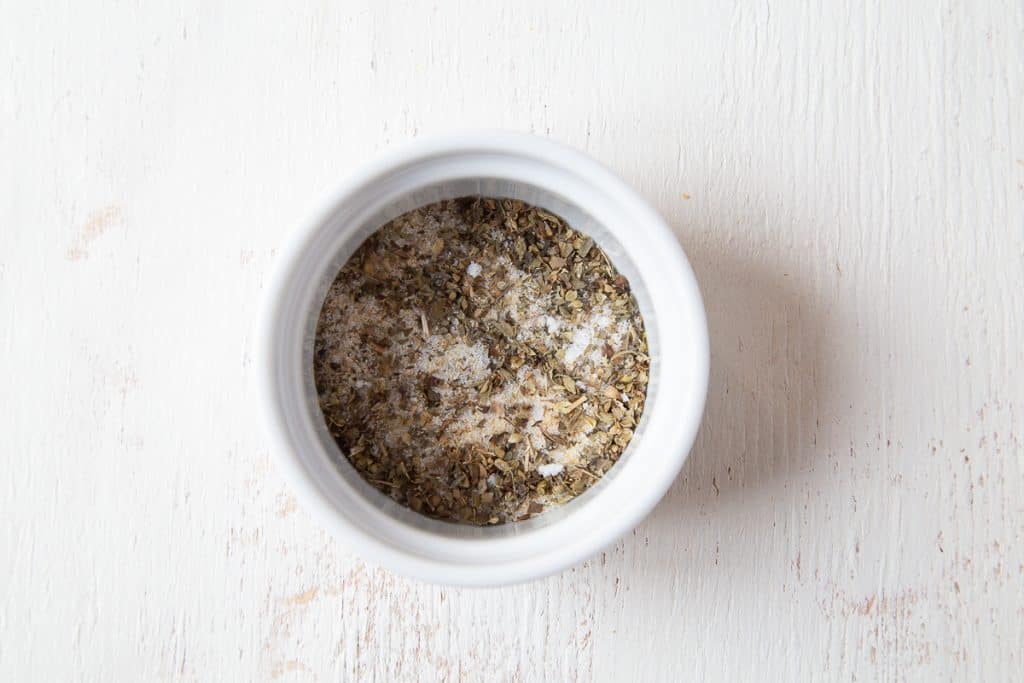 salt and dried herbs in a small white ramekin.