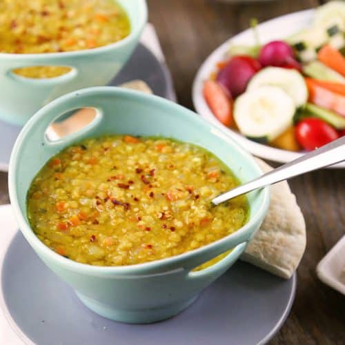 bowl of lemon lentil soup topped with red pepper flakes in a turquoise bowl