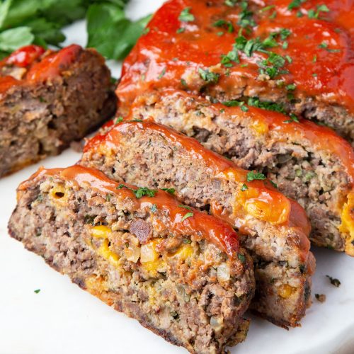 slices of bacon cheddar meatloaf on a white serving platter