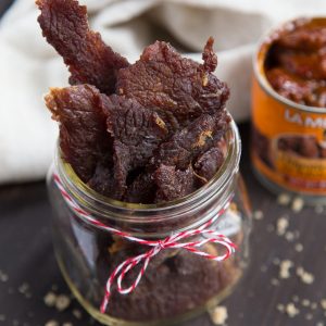 beef jerky in a glass jar with a red and white ribbon