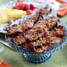praline bacon piled on a blue glass cake stand