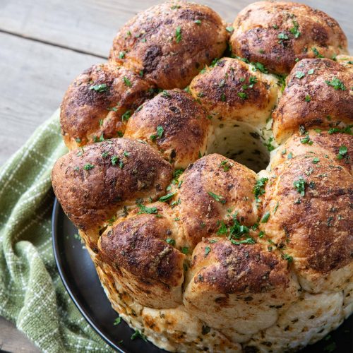 pull apart garlic bread on a green tea towel