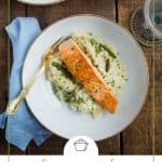salmon over risotto on a white china plate.