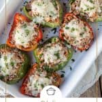 Italian stuffed peppers topped with cheese and parsley in a white casserole dish.