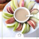 caramel apple dip and apple slices on a round plate.